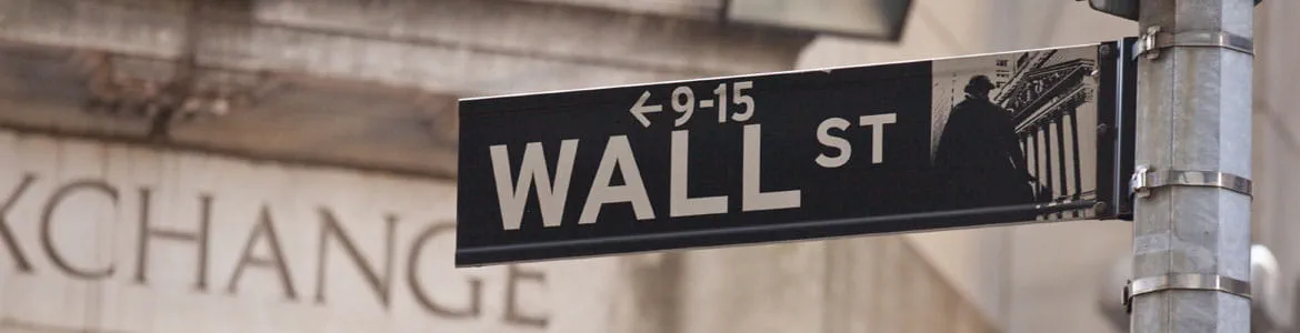 Wall Street sign with a building in background